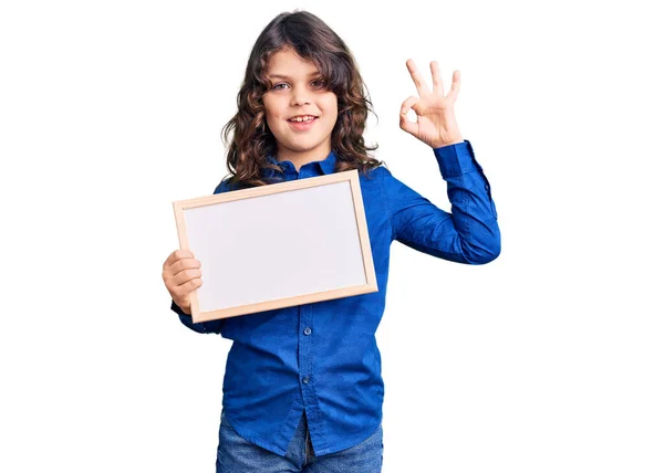 可爱的毛茸茸的孩子拿着空白的白板 用手指签着名 微笑着友好的手势 是极好的象征 — 图库照片