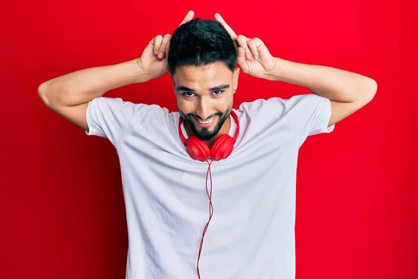 Молодой Человек Бородой Слушает Музыку Используя Наушники Изображающие Смешного Сумасшедшего — стоковое фото