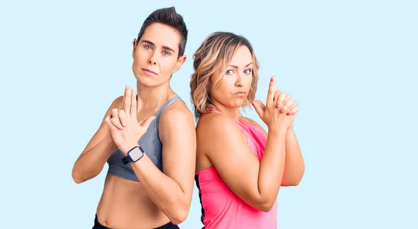 Couple Women Wearing Sportswear Holding Symbolic Gun Hand Gesture Playing — Stock Photo, Image