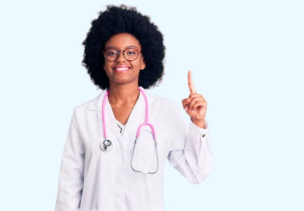 自信と幸せ笑顔ながら医師のコートと聴診器を身に着けている若いアフリカ系アメリカ人女性 — ストック写真