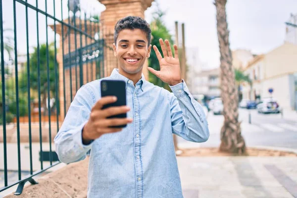 若いラテン語の男の笑顔幸せな行うビデオ通話を使用してスマートフォンで市内 — ストック写真