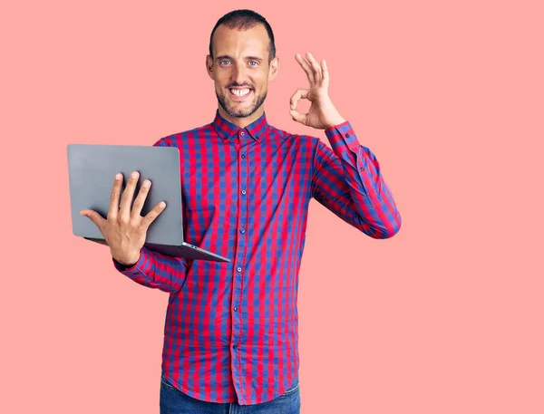 컴퓨터 랩탑을 사용하여 일하고 잘생긴 남자가 손가락으로 글씨를 다정하게 미소짓고 — 스톡 사진