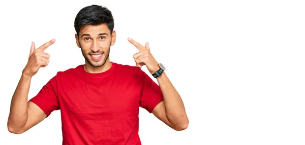 Junger Gutaussehender Mann Lässigem Rotem Shirt Lächelt Und Zeigt Mit — Stockfoto