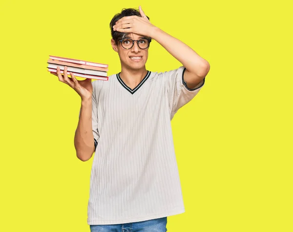 Young Hispanic Man Holding Books Stressed Frustrated Hand Head Surprised — Stock Photo, Image