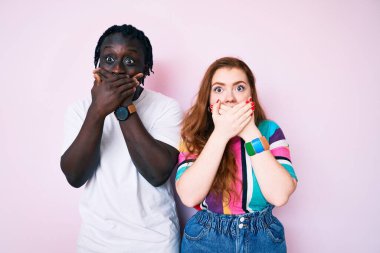 Gündelik giysiler giyen ırklar arası bir çift yanlışlıkla ağızlarını kapatarak şok geçirdi. gizli kavram. 