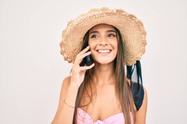 Genç İspanyol kadın tatilde. Şehir caddesinde akıllı telefondan konuşuyor.