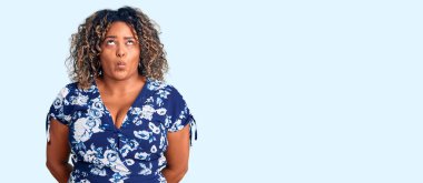 Genç Afro-Amerikan artı cüsseli kadın günlük kıyafetler giyiyor dudaklarıyla balık suratı yapıyor, çılgınca ve komik jestler yapıyor. Komik ifade. 