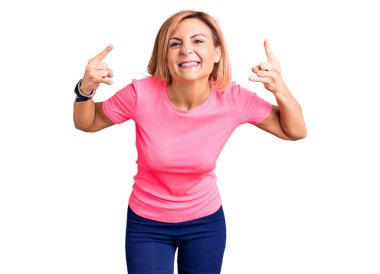 Spor kıyafetleri giymiş, çılgın bir ifadeyle bağıran genç sarışın kadın elleri havada rock sembolü yapıyor. Müzik yıldızı. ağır müzik konsepti. 