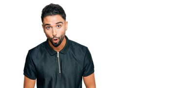 Sakallı genç adam spor giyer. Korkmuş ve şok olmuş bir ifadeyle, korkuyla ve heyecanlı yüzüyle. 