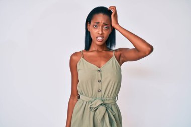 Gündelik giysiler giyen genç Afro-Amerikan kadın soru işaretlerini karıştırıyor ve merak ediyor. Şüpheyle kararsız, kafa kafaya düşünerek. Düşünceli kavram. 