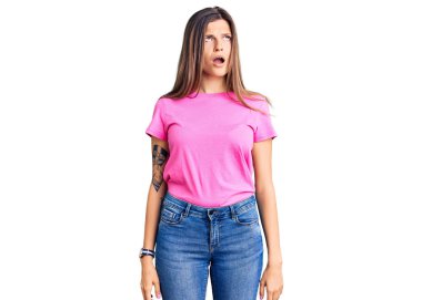 Şok olmuş gibi giyinmiş, kuşkucu ve alaycı görünen, ağzı açık, güzel, beyaz bir kadın. 