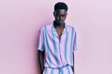 Gündelik kıyafetler giyen, kuşkucu ve gergin, sorun yüzünden surat asan genç Afro-Amerikan. negatif kişi. 