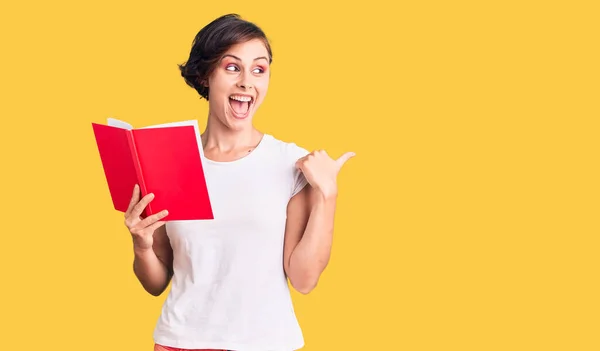 Hermosa Joven Con Pelo Corto Leyendo Libro Apuntando Pulgar Hacia — Foto de Stock