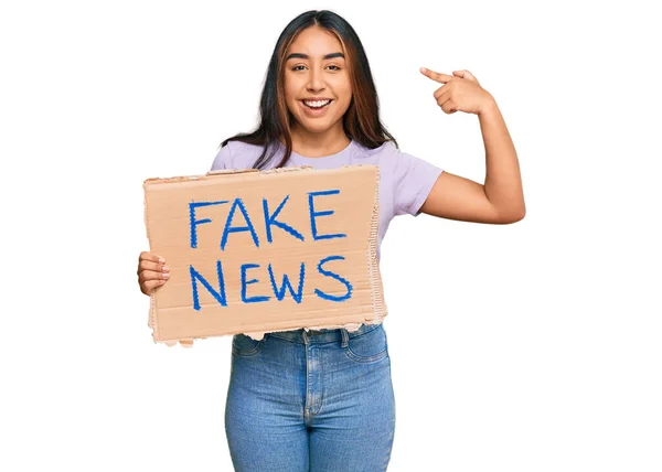 Young Latin Woman Holding Fake News Banner Pointing Finger One — Stock Photo, Image