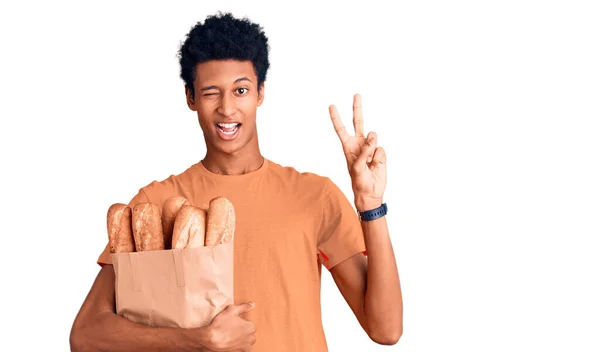 Joven Hombre Afroamericano Sosteniendo Bolsa Papel Con Pan Sonriendo Con — Foto de Stock