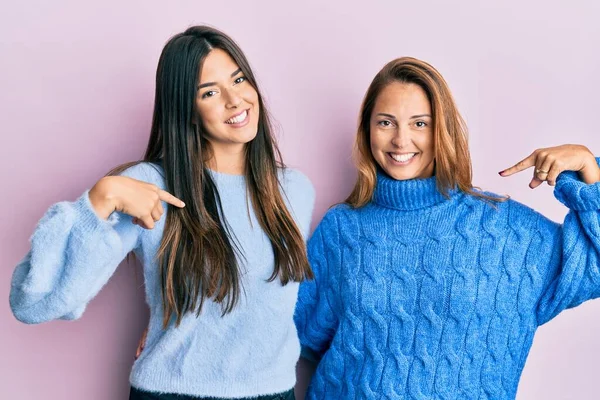 西班牙家庭的母亲和女儿穿着羊毛衫 面带微笑 满脸自信 用手指指着自己 自豪而快乐 — 图库照片