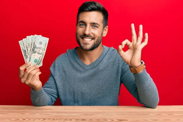 Handsome Hispanic Man Holding Dollars Banknotes Doing Sign Fingers Smiling — Stock Photo, Image