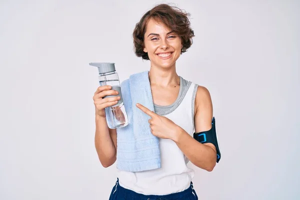 Jonge Spaanse Vrouw Draagt Sportkleding Handdoek Drinken Fles Water Glimlachend — Stockfoto