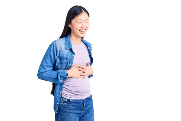 年轻美丽的中国女人怀孕了 期待着孩子笑着大声笑着 因为一个滑稽的疯狂笑话 双手放在身上 — 图库照片