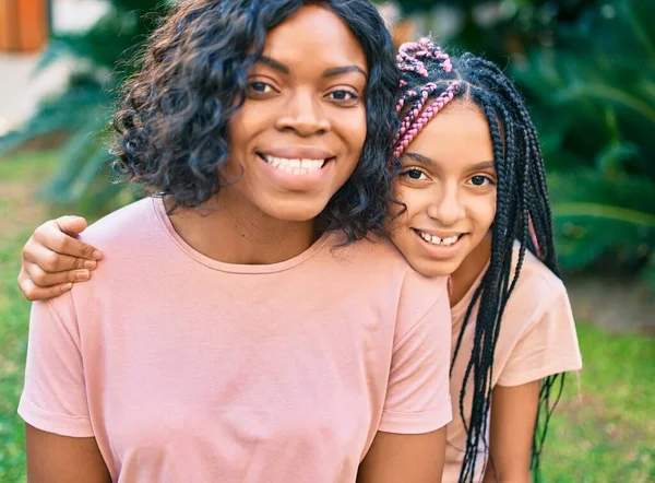 美しいアフリカ系アメリカ人の母親と娘の笑顔と抱擁 公園に立って笑顔で立って — ストック写真
