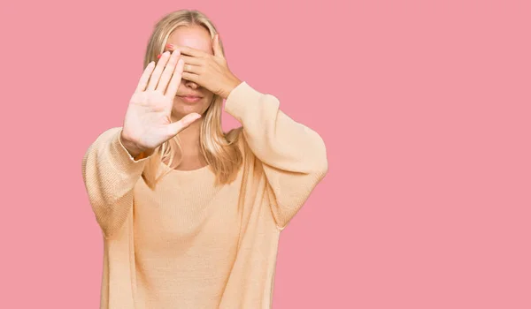 Młoda Blondynka Luźnych Ubraniach Przykrywających Oczy Dłońmi Wykonujących Stop Gestu — Zdjęcie stockowe