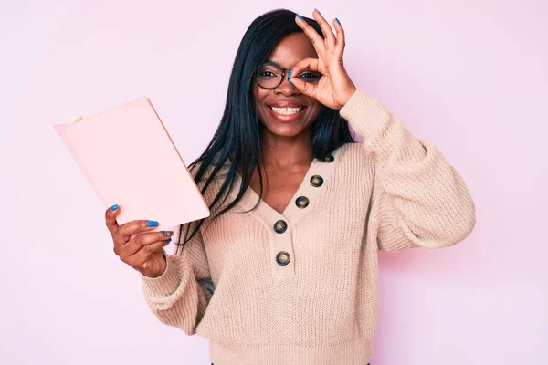 Νεαρή Αφροαμερικάνα Γυναίκα Φορώντας Γυαλιά Κρατώντας Βιβλίο Χαμογελώντας Ευτυχισμένη Κάνει — Φωτογραφία Αρχείου