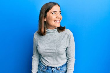 Balıkçı yaka kazak giyen genç beyaz kadın yanlışlıkla elleri ile ağzını kapatırken şok oldu. gizli kavram. 