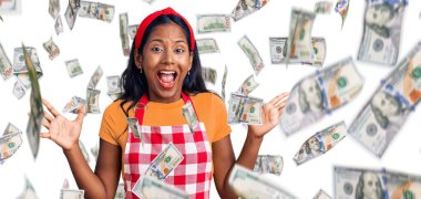 Genç Hintli kız profesyonel fırıncı önlüğü giyerek çılgınlığı kutluyor ve başarıya hayret ediyor kolları açık ve gözleri açık heyecanla haykırıyor. Kazanan konsept