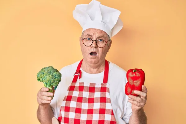 Ανώτερος Γκριζομάλλης Άντρας Που Φοράει Επαγγελματική Ποδιά Μάγειρας Κρατώντας Μπρόκολο — Φωτογραφία Αρχείου