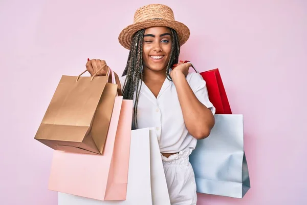 Junge Afrikanisch Amerikanische Frau Mit Zöpfen Und Einkaufstaschen Zwinkernd Die — Stockfoto