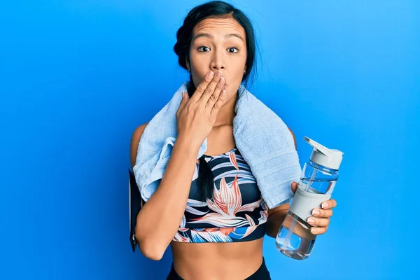 美しいヒスパニック系の女性は 手で口をカバーウォーターボトルを保持スポーツウェアを着てショックを受け 間違いを恐れている 驚きの表情 — ストック写真