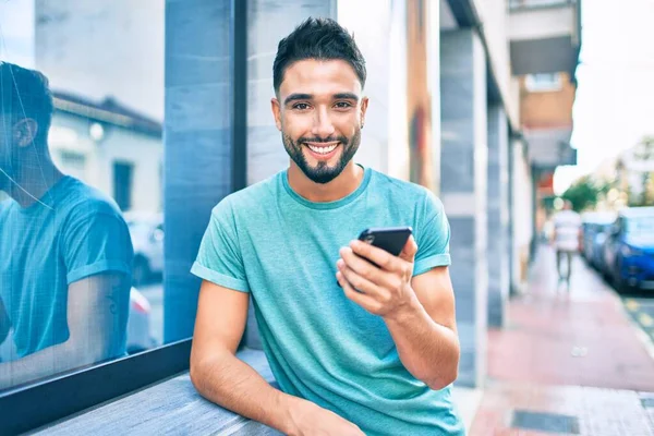 Hombre Árabe Joven Sonriendo Feliz Usando Teléfono Inteligente Ciudad —  Fotos de Stock