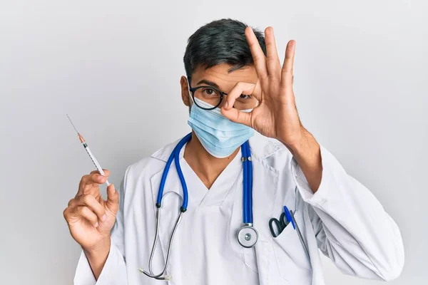 Młody Przystojny Mężczyzna Nosi Mundur Lekarza Maskę Medyczną Trzymając Strzykawkę — Zdjęcie stockowe