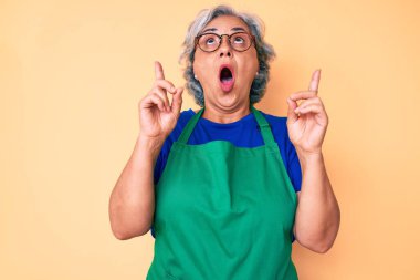 Önlük ve gözlük takan son sınıf İspanyol kadın hayret ve şaşkınlık içinde başını kaldırıp parmaklarıyla işaret etti ve kollarını kaldırdı.. 