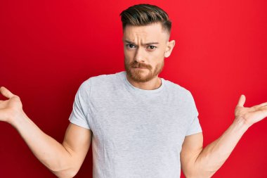 Genç, kızıl saçlı, sıradan gri tişörtlü, bilgisiz ve kolları açık, hiçbir fikrim yok ve şüpheli bir yüzüm var.. 