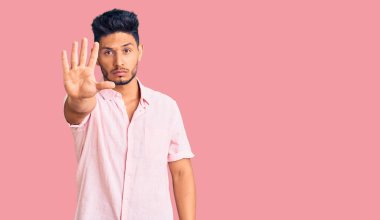 Yazlık tişört giyen yakışıklı Latin Amerikalı genç adam avucunun içi gibi şarkı söylemeyi kesiyor. Yüzünde olumsuz ve ciddi bir jest olan uyarı ifadesi. 