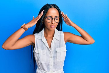 Güzel İspanyol kadın günlük kıyafetler giyiyor ve eli başının üstünde gözlük takıyor. Stres yüzünden baş ağrısı çekiyor. migren ağrısı. 