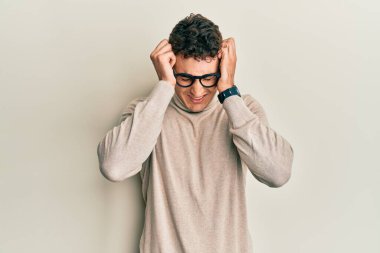 Balıkçı yaka kazak giyen İspanyol genç adam acı ve migren yüzünden çaresiz ve stresli bir baş ağrısı çekiyor. Eller başının üstünde.. 