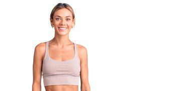 Güzel beyaz kadın spor giysisi giyiyor ve yüzünde mutlu ve havalı bir gülümseme var. şanslı kişi. 