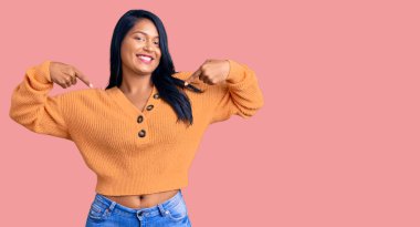 Uzun saçlı, sıradan bir kazak giyen, kendine güvenen, gülümseyen, kendini gururlu ve mutlu gösteren İspanyol bir kadın.. 