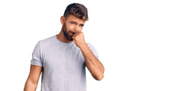 Gündelik kıyafetler giyen genç İspanyol adam pis ve iğrenç bir koku alıyor, dayanılmaz bir koku, nefesini burnunda tutuyor. Kötü kokuyor. 