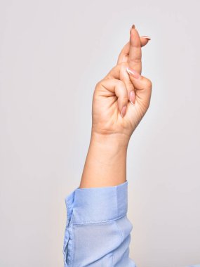 Beyaz arka planda şans işareti yapan beyaz tenli bir kadının eli.