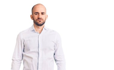 Yüzünde ciddi bir ifade olan zarif bir gömlek giyen genç yakışıklı bir adam. Basit ve doğal bir şekilde kameraya bakıyorsun.. 