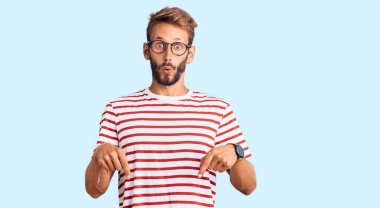 Sakallı, sıradan giyinen ve gözlüklü yakışıklı bir adam parmaklarını göstererek reklamını yapıyor, şaşırmış yüzünü ve ağzını açıyor. 