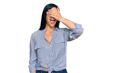 Gündelik giysiler giymiş genç beyaz bir kadın. Gülümsüyor ve elleri yüzüne gülüyor. Şaşırtmak için gözleri örtüyor. kör kavram. 