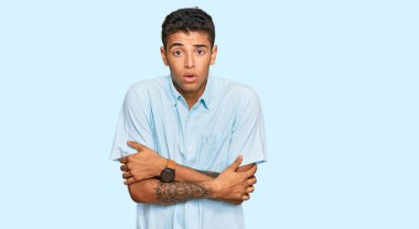 Genç, yakışıklı, Afro-Amerikalı, günlük kıyafetler giymiş. Kış soğuğu için titriyor ve donuyor. Yüzünde üzgün ve şok ifadesi var. 