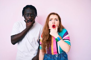 Gündelik kıyafetler giyen ırklar arası bir çift inançsızlığa, şaşkınlığa ve elleri çenesinde şaşkınlığa kapılmış bir ifade takınıyor. 