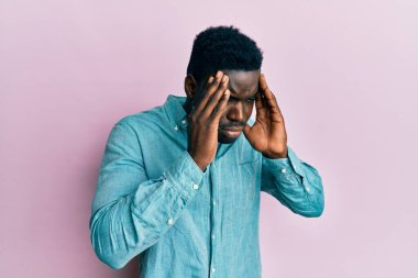 Yakışıklı siyahi adam, stresten dolayı başı ağrıyan günlük kıyafetler giyiyor. migren ağrısı. 