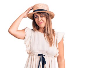 Yaz şapkası ve tişörtü giyen genç ve güzel bir kadın soru işaretlerini karıştırıyor. Şüpheyle kararsız, kafa kafaya düşünerek. Düşünceli kavram. 