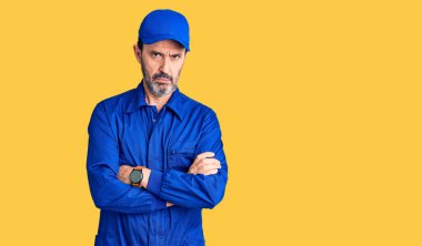 Orta yaşlı, yakışıklı, mekanik üniformalı, kuşkucu ve gergin bir adam. Yüzünde çapraz kollu, onaylamayan bir ifade var. negatif kişi. 